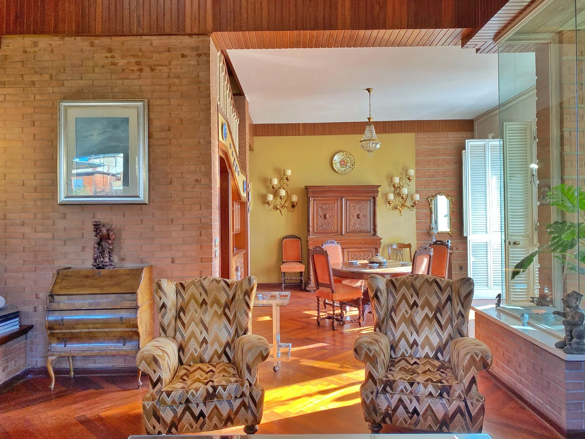 Lounge with armchairs and exposed-brick dining room