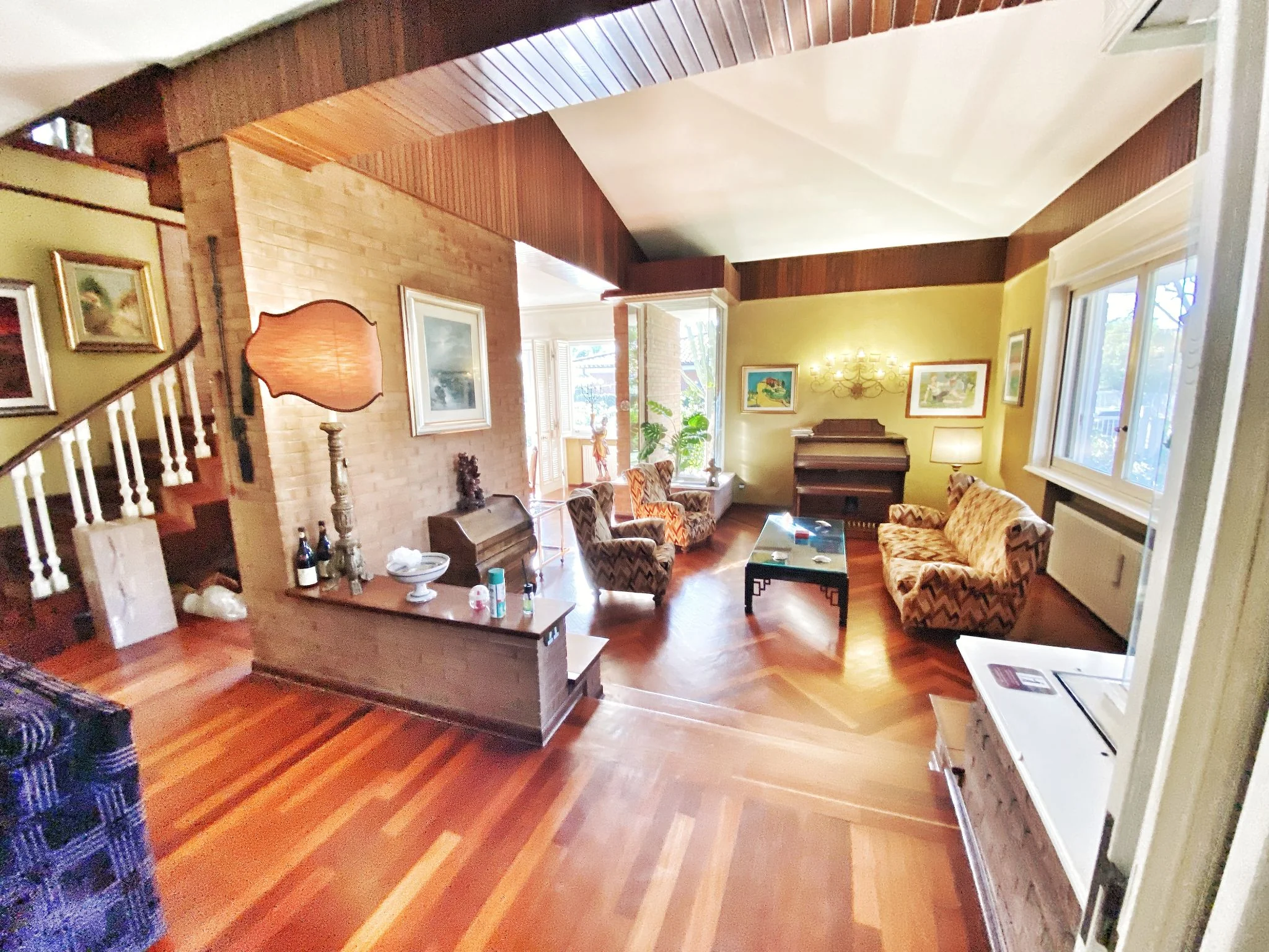 Living room with a view of the staircase and the piano